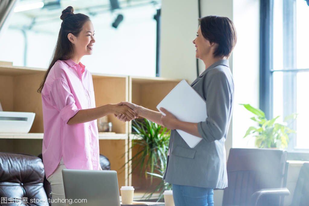 快樂的女實業家在談判后互相握手打招呼